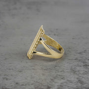 10k - 14k Gold ring with rectangular design sideview on a gray surface