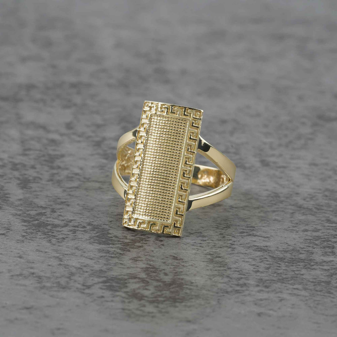 10k - 14k Gold ring with rectangular design on a gray surface