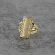 10k - 14k Gold ring with rectangular design on a gray surface