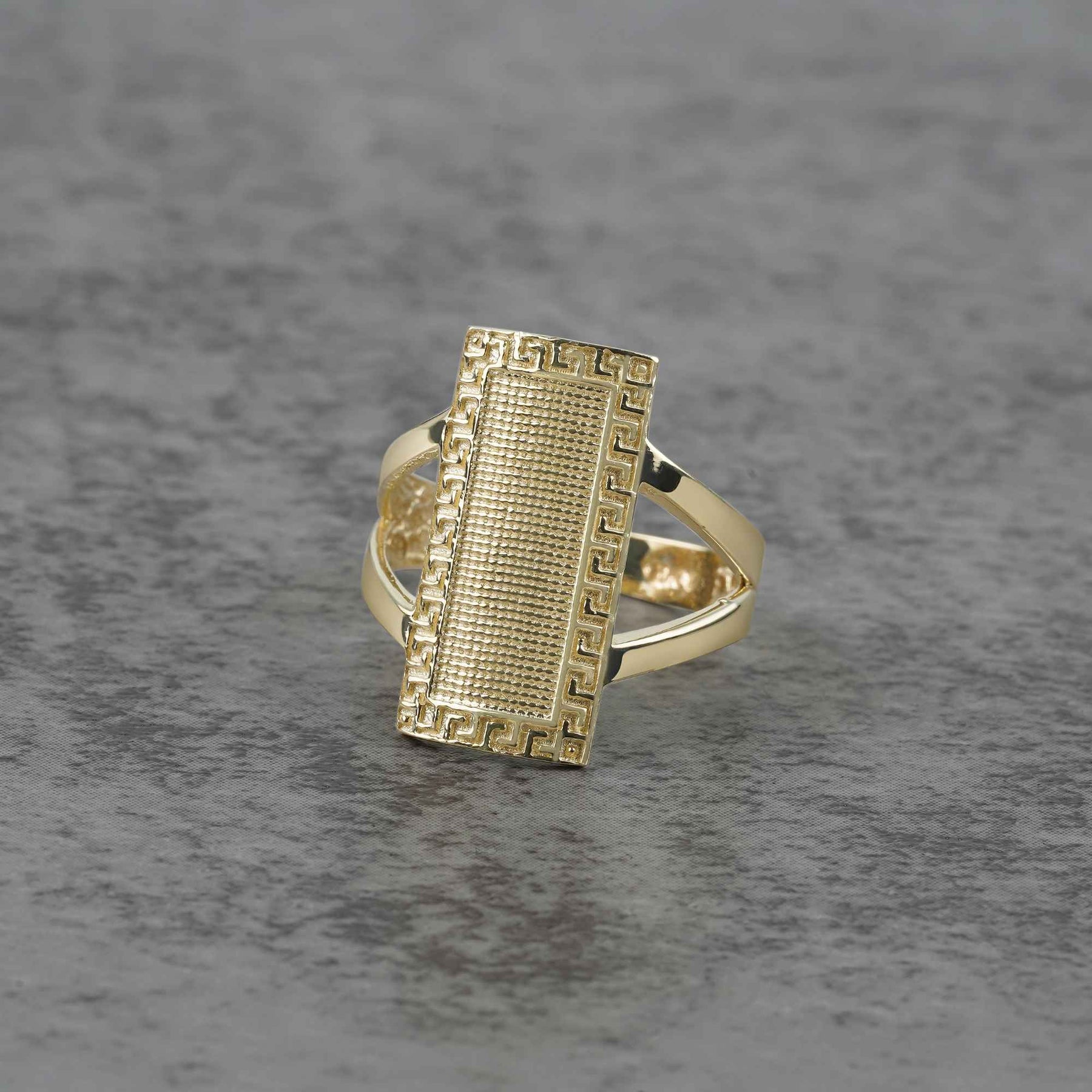 10k - 14k Gold ring with rectangular design on a gray surface