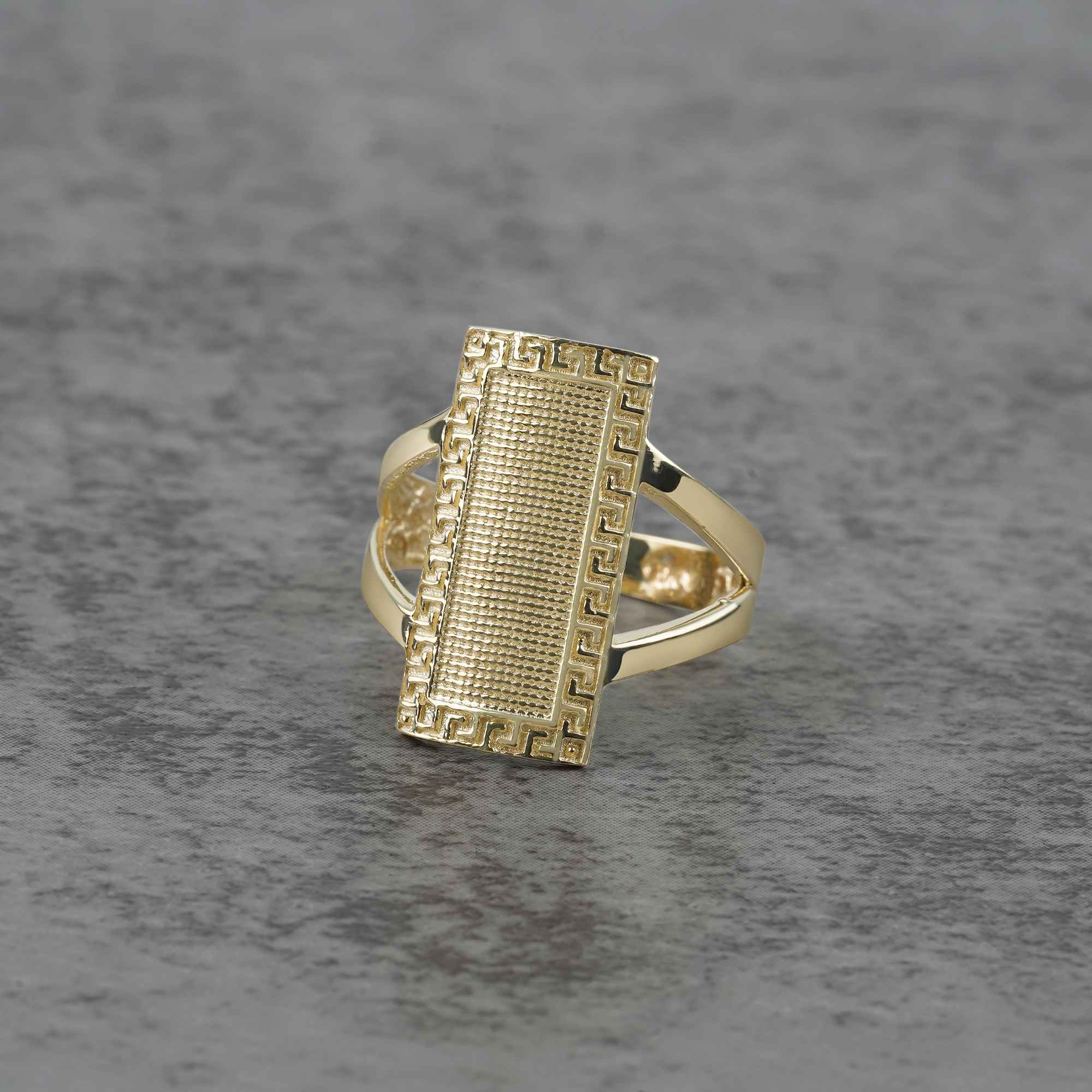10k - 14k Gold ring with rectangular design on a gray surface