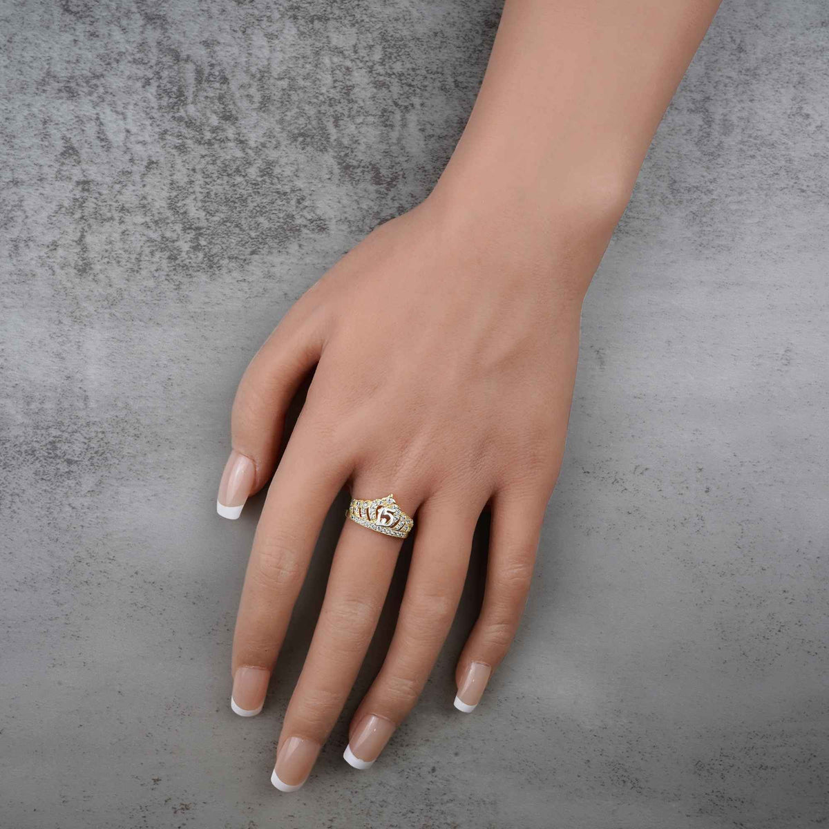 hand wearing a 10k -14k gold ring with a crown shape and number 15 design 