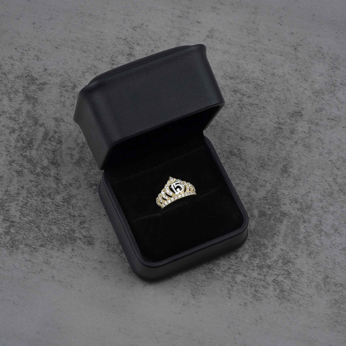 10k - 14k gold ring with a crown and number 15 design in a black jewelry box 