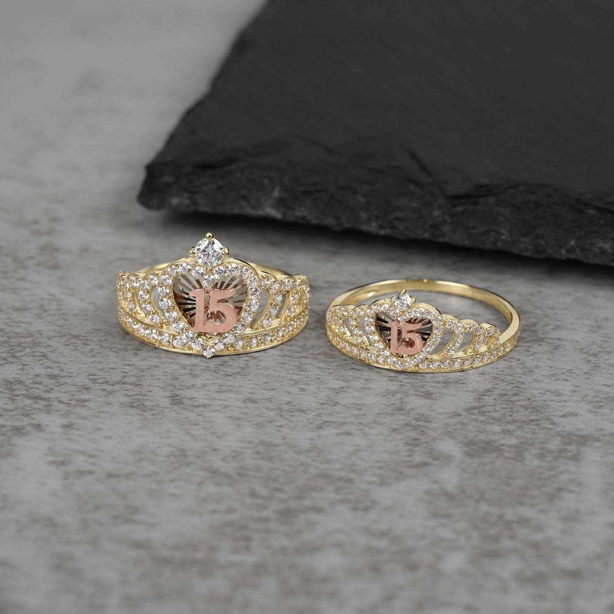 Large and medium gold crown rings with a rose gold 15 on stone