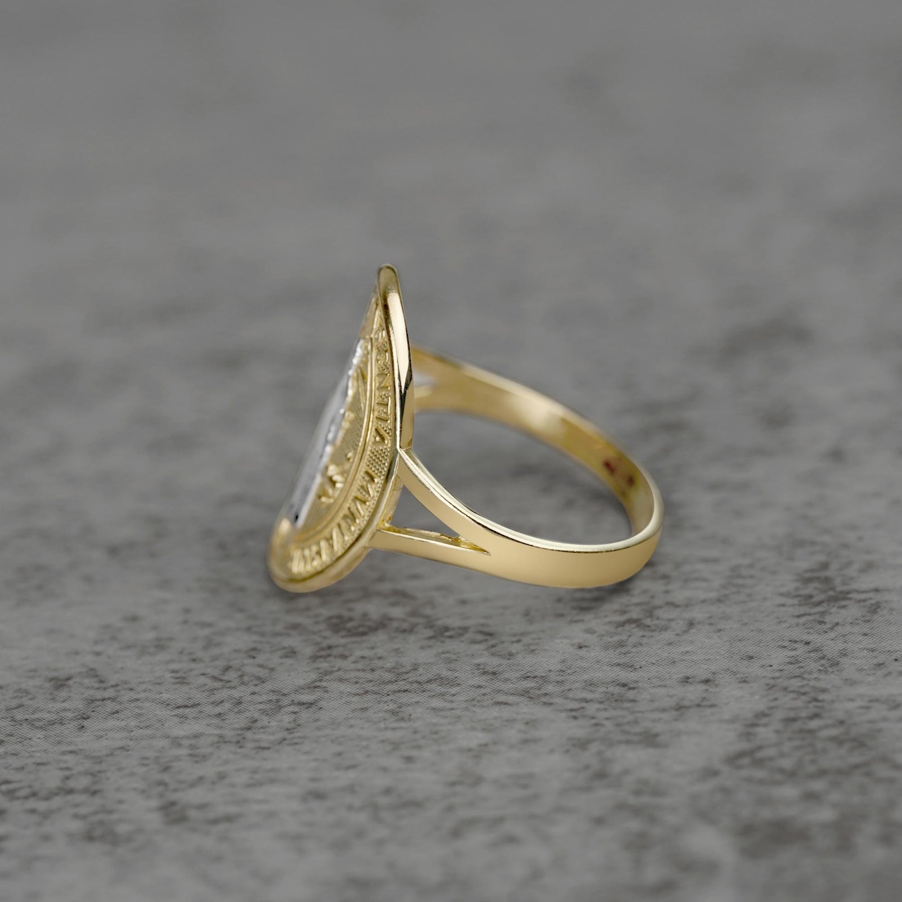 10k - 14k Saint Benedict Oval Gold ring side view on a gray surface