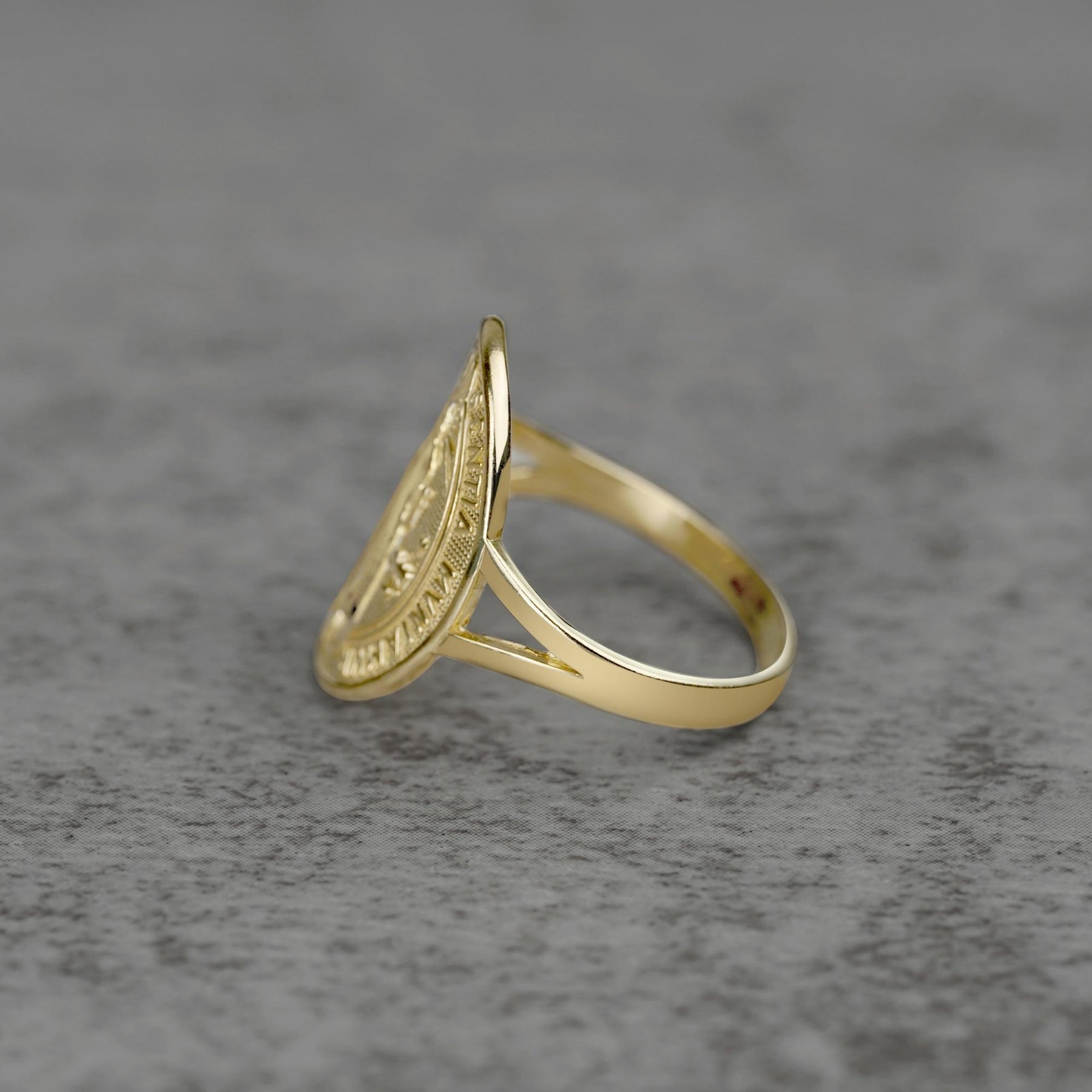 10k - 14k Saint Benedict Oval gold Ring  sideview on a gray background
