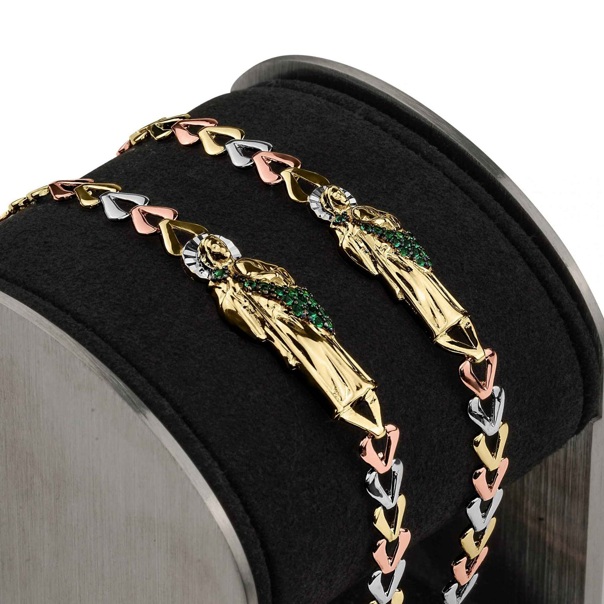 Two tricolor gold San Judas bracelets draped over a black display stand.