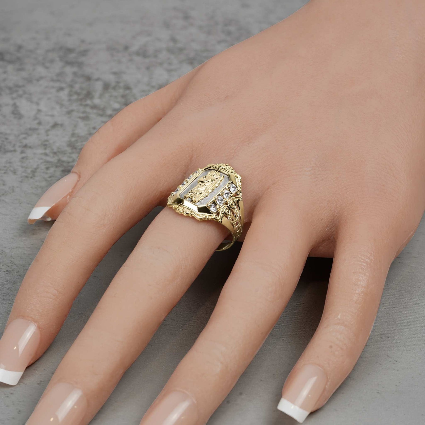 Mannequin hand wearing a two-tone gold San Judas royal ring with cubic zirconia.