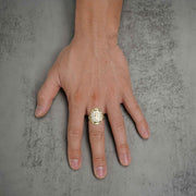 Top-down view of a hand wearing a two-tone gold San Judas royal ring.
