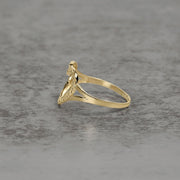 Side view of a 10k and 14k gold open-heart nugget ring on a textured background.