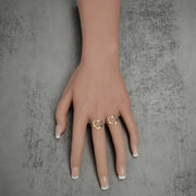 Two 10k and 14k gold open-heart nugget rings worn on a hand against a gray background.