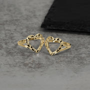 Two 10k and 14k gold open-heart nugget rings displayed on a textured surface.