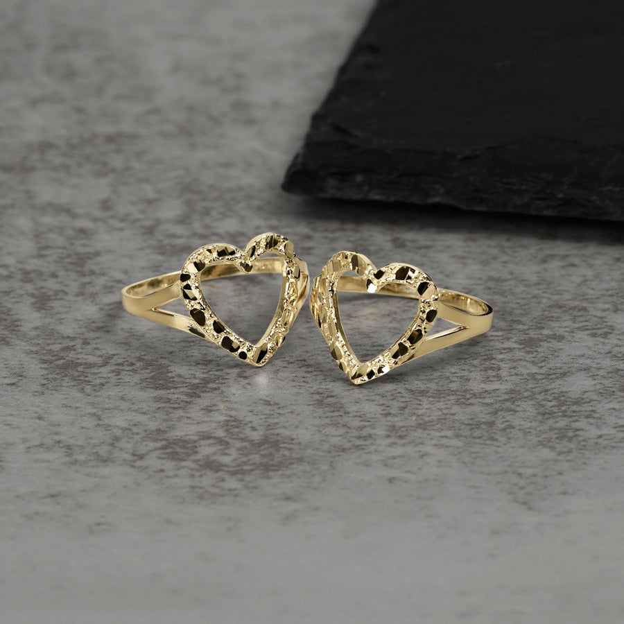 Two 10k and 14k gold open-heart nugget rings displayed on a textured surface.