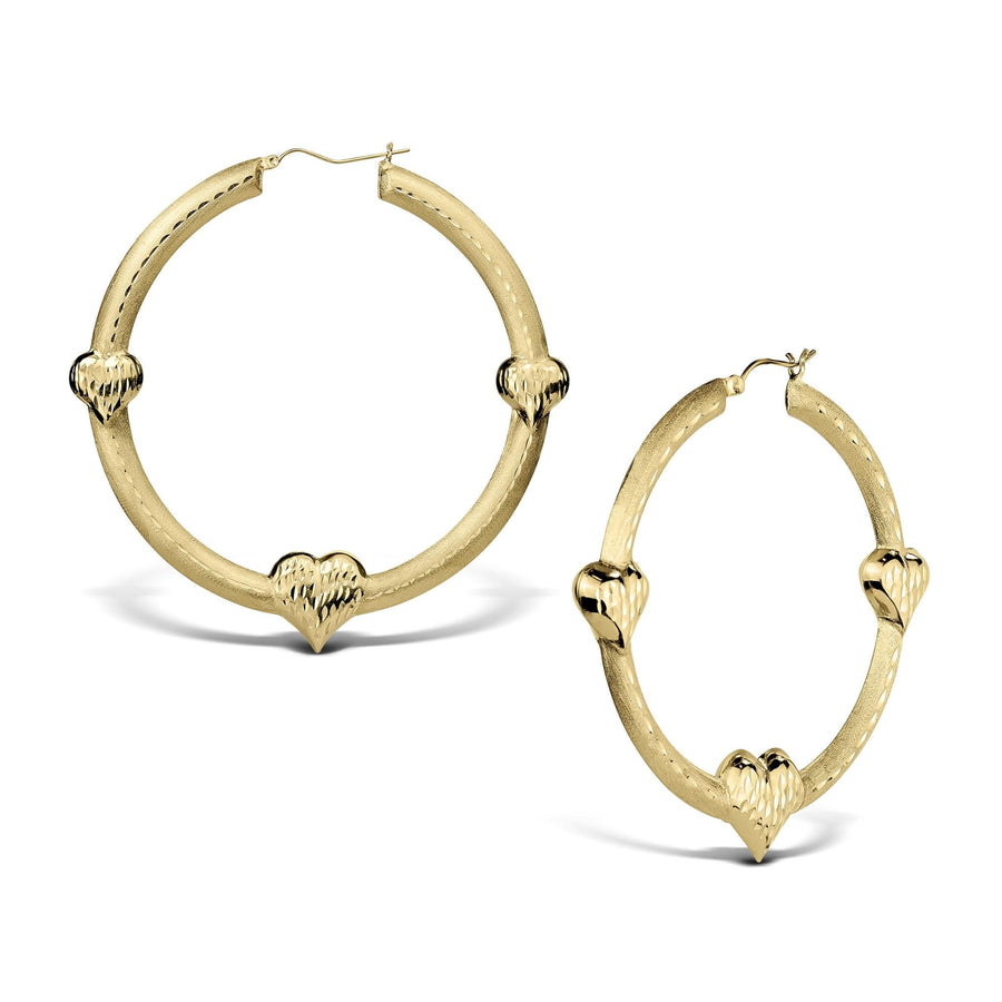 Two textured gold hoop earrings featuring three diamond-cut heart accents on a white background.