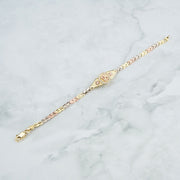 Delicate tri-color gold leaf bracelet featuring a pavé-set "15 Anos" center charm.