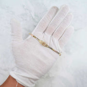Close-up of the tri-color gold Quinceañera leaf bracelet showcased on a gloved hand.