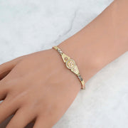 Close-up of the tri-color gold quinceañera leaf bracelet showing the central "15" charm detail.