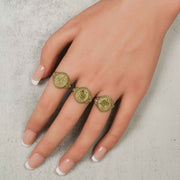 Three different gold zodiac constellation signet CZ rings modeled on a hand.