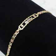Tri-color gold quinceañera leaf bracelet displayed on a black velvet stand.