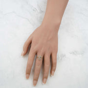 Hand wearing the polished tricolor gold Virgin Mary ring against a marble background.