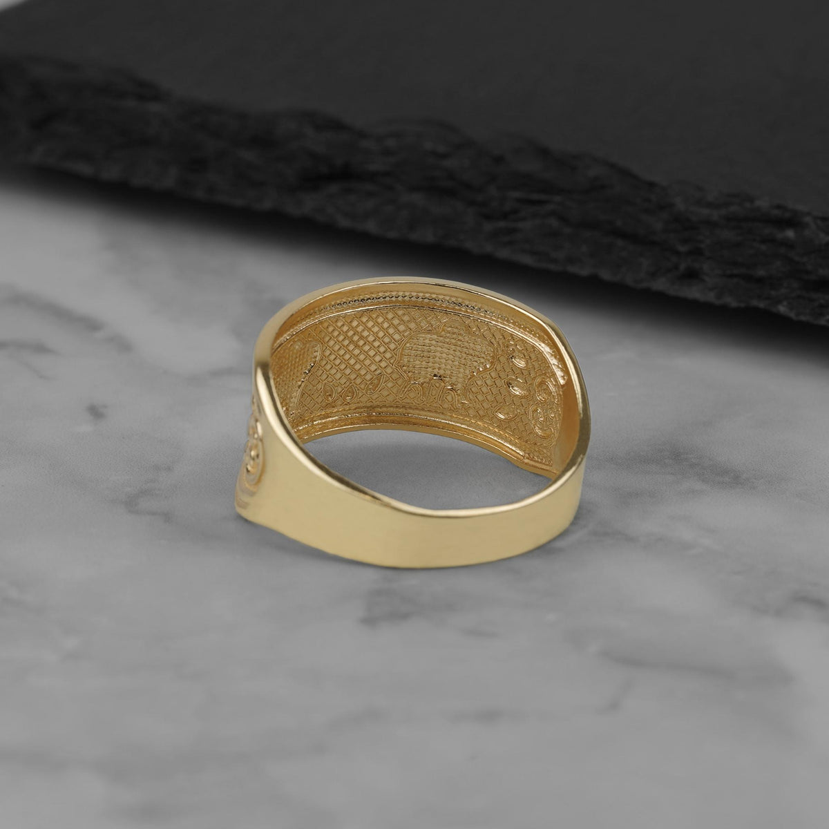 Underside view of a tricolor gold elephant ring showcasing its hollow-backed interior structure.