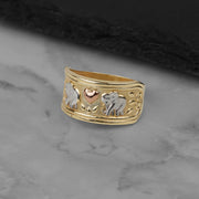 Tri-color gold elephant ring featuring detailed engravings resting on a marble surface.