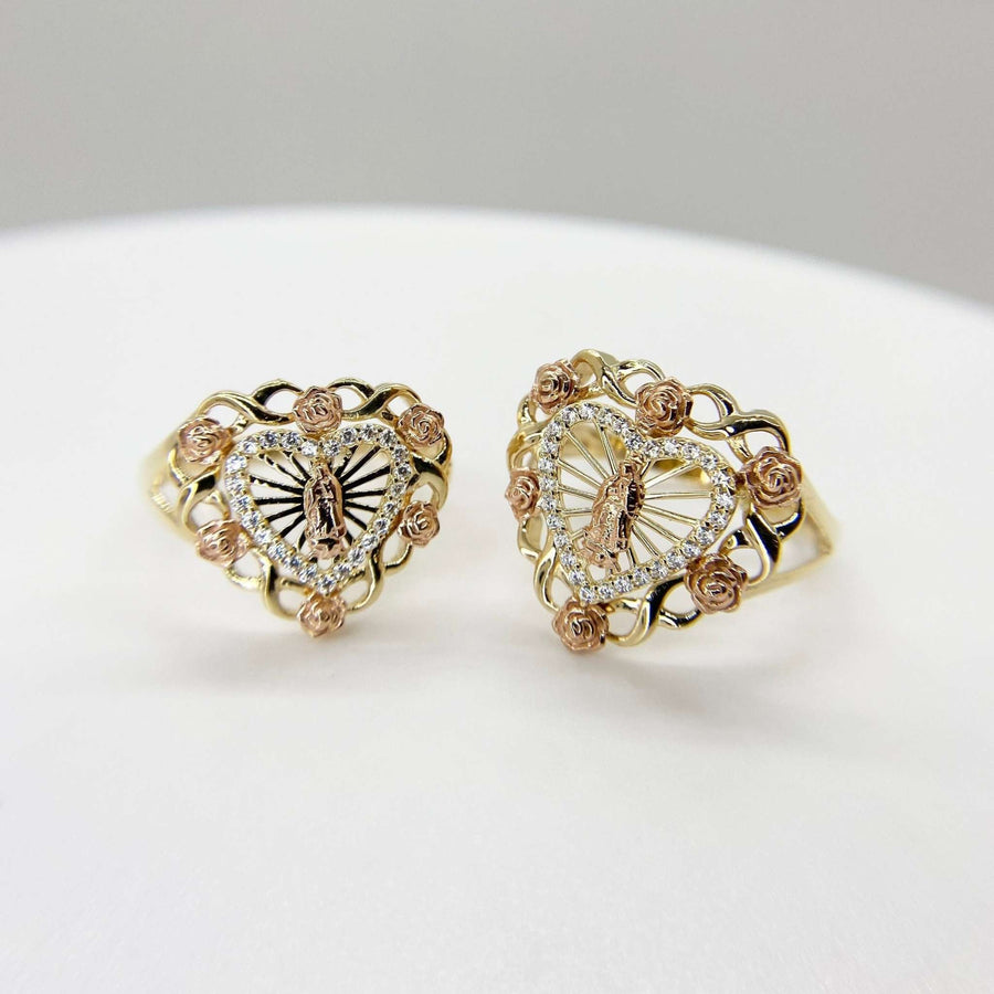 two Heart shaped 10k - 14k gold rings with Virgin Mary and Virgen Maria Lady Guadalupe designs on a white surface
