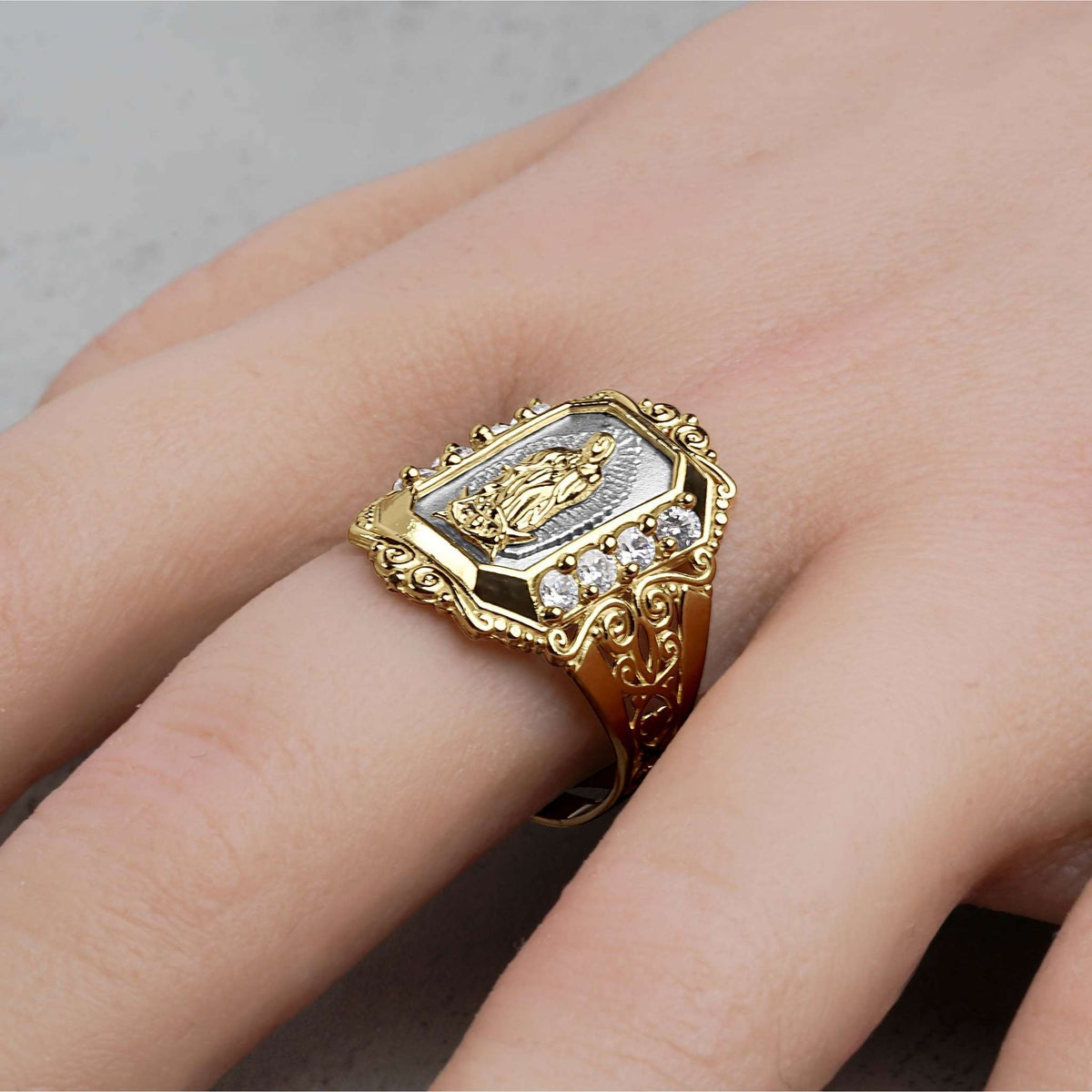 wo-tone gold Virgin Mary ring with cubic zirconia accents worn on a hand.