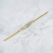 Back view of a gold Quinceañera "15 Años" leaf link bracelet on marble.