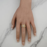 Tricolor gold Quinceañera ring with number 15 worn on a hand against marble.