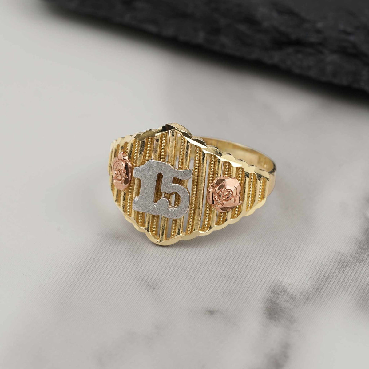 Tricolor gold Quinceañera ring with number 15 and rose gold floral details.