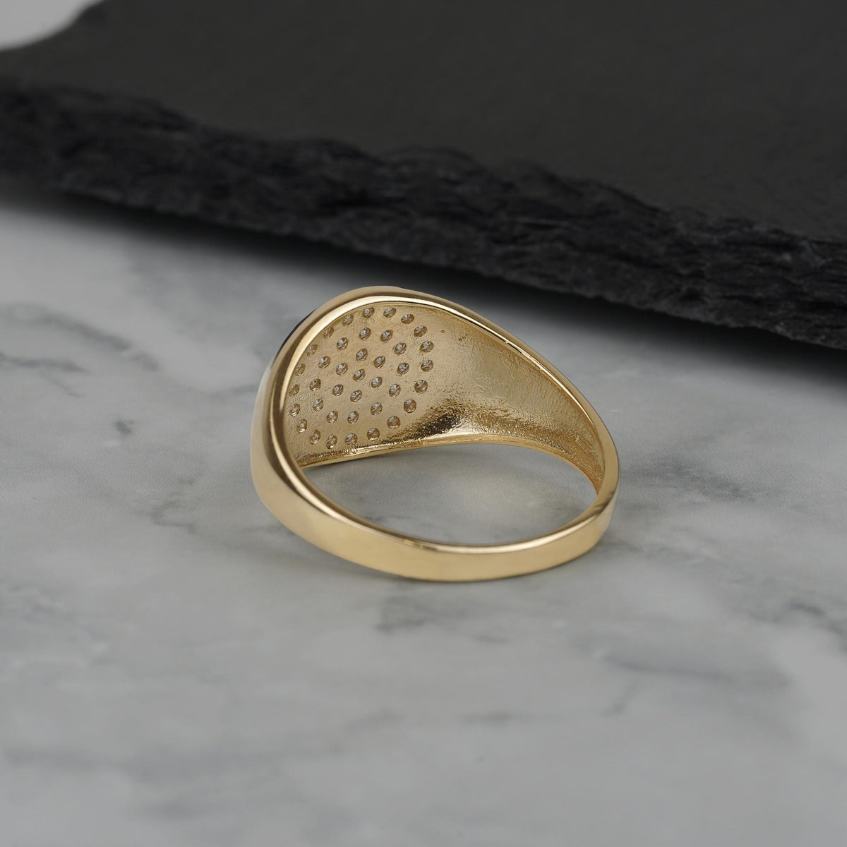Inside view showing back pattern and structure of a gold round signet ring.