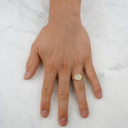 Man wearing a round gold signet ring with paved CZ stones on his hand.