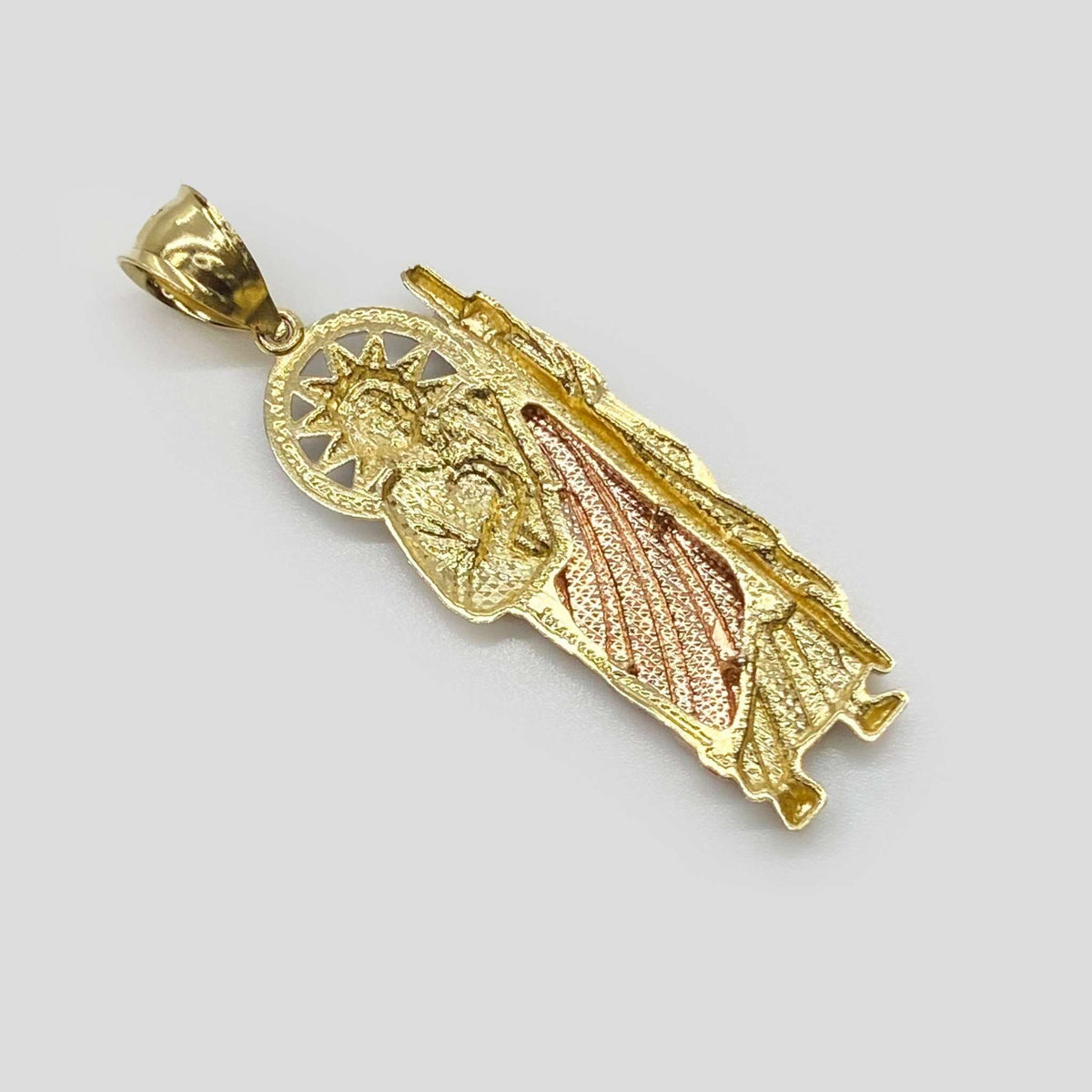 Back view of tri-color gold San Judas pendant showing diamond-cut textured pattern.