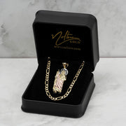 Tri-color 10k or 14k gold San Judas pendant displayed inside an open black velvet jewelry box with gold branding.