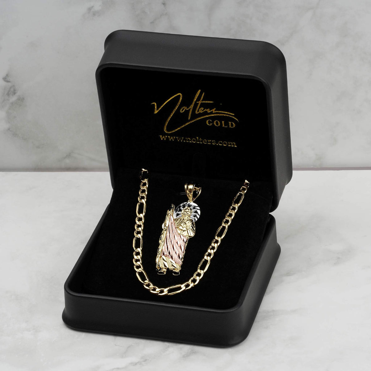 Tri-color 10k or 14k gold San Judas pendant displayed inside an open black velvet jewelry box with gold branding.
