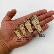 Hand holding four sizes of tri-color gold Saint Jude Thaddeus religious pendants with size labels.