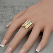 Model wearing a men's 10k two-tone gold rectangular Grim Reaper signet ring on finger.