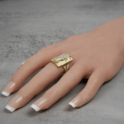 Bold yellow gold rectangular statement ring featuring a white gold death reaper design worn casually.