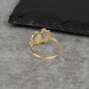 Inside view of a tri-color gold heart ring showing the detailed back pattern.
