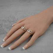 Close-up of a hand displaying small and medium sizes of the Guadalupe heart ring.