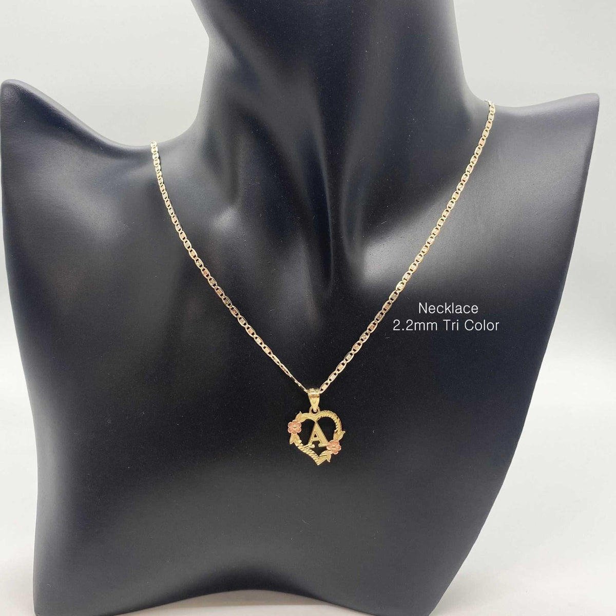 Gold heart initial pendant with letter A featured on a black mannequin display bust.