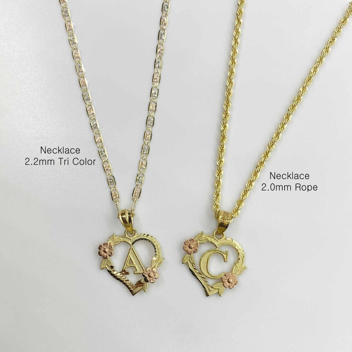 Two gold floral heart initial necklaces labeled by chain style on light background.