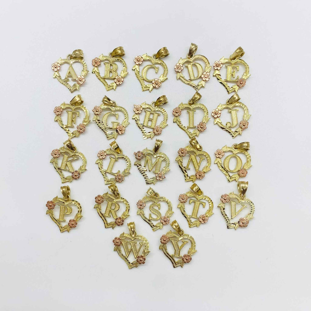 Assortment of two-tone gold heart initial charms featuring rose accents from A to Y.