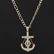 Two-tone gold crucifix anchor pendant necklace with sparkling cubic zirconia on dark backdrop.