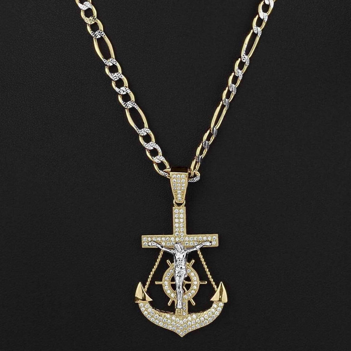 Two-tone gold crucifix anchor pendant necklace with sparkling cubic zirconia on dark backdrop.