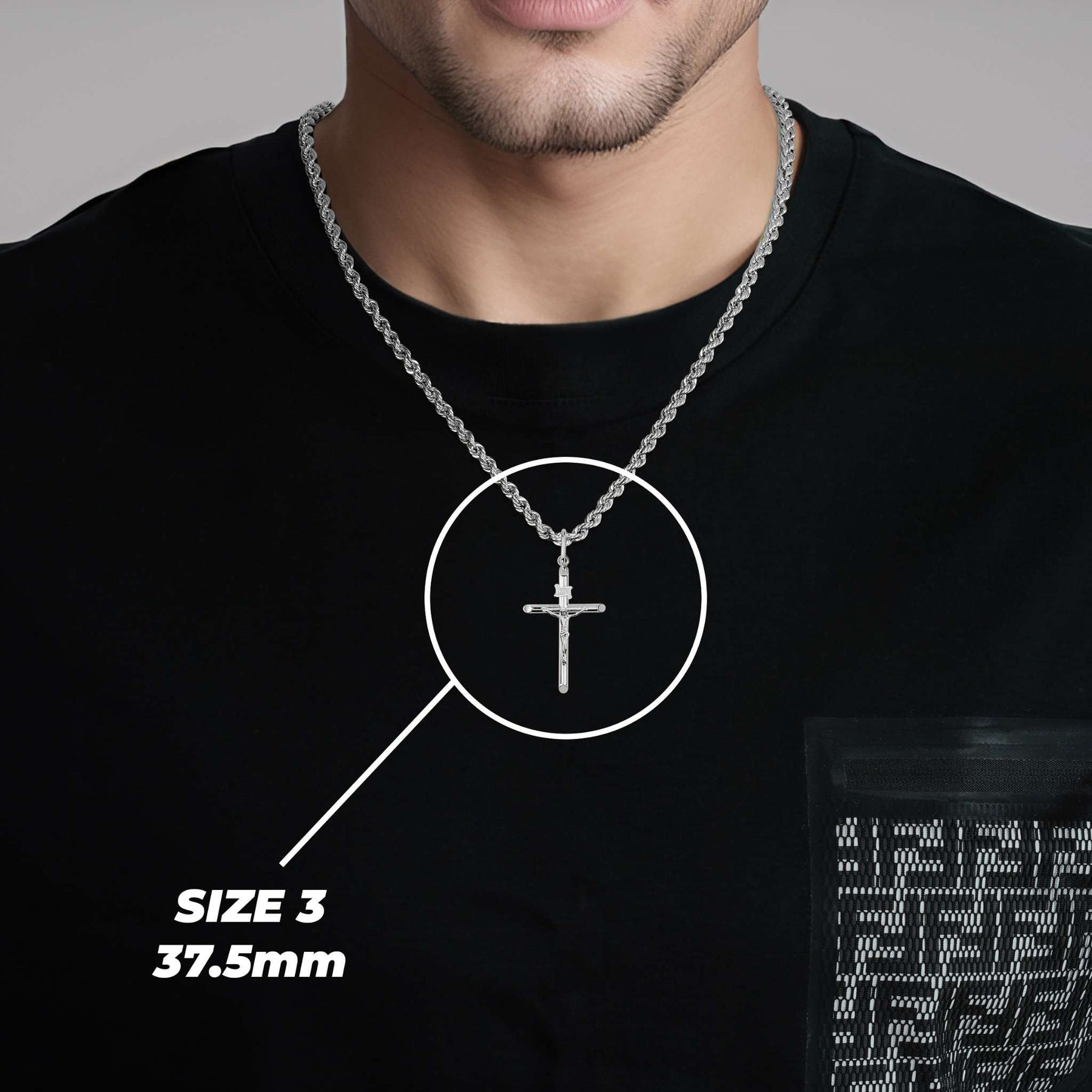 Man wearing a size 3 (37.5mm) white gold tubular INRI crucifix pendant on a black shirt.