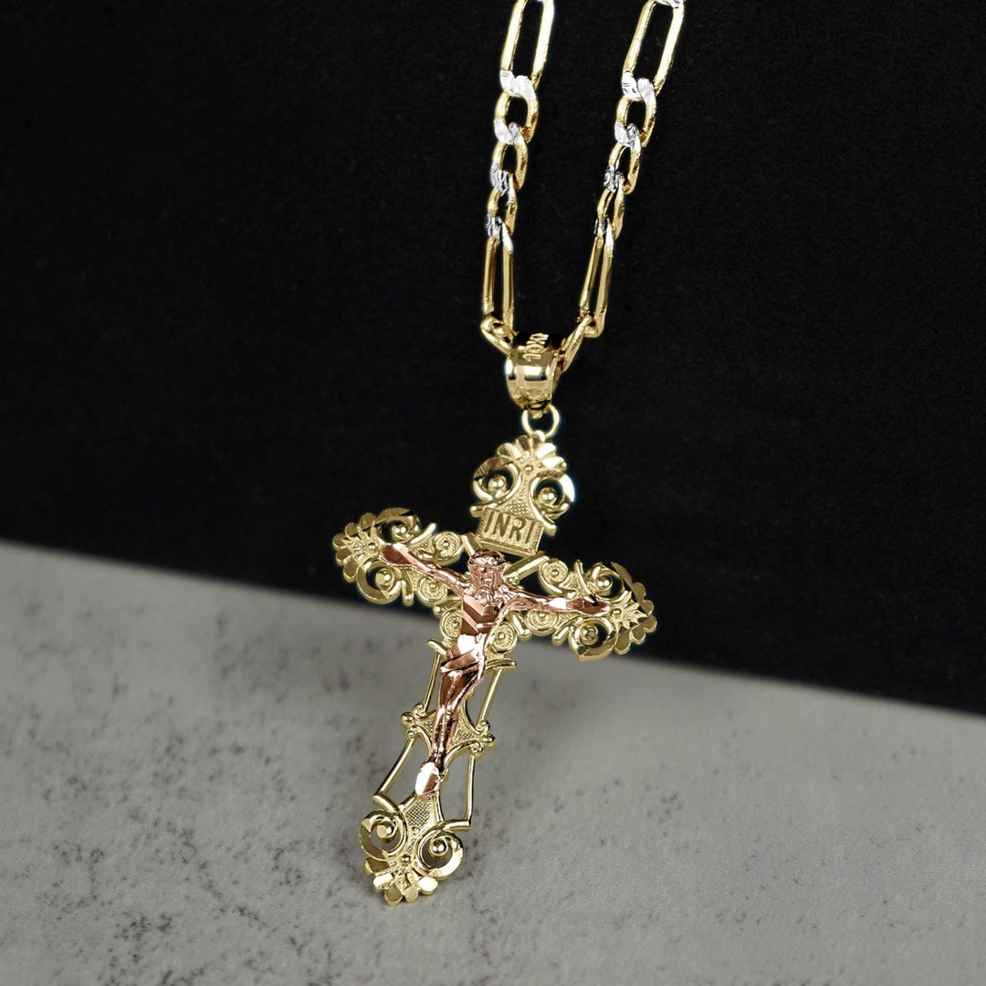 Gold cross pendant with rose gold corpus, hanging from a gold chain on split background.