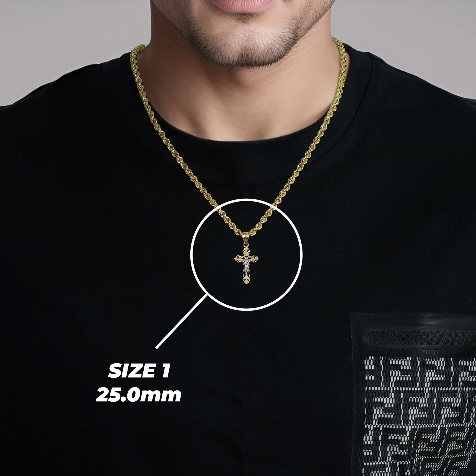 Man wearing a size 1 gold cross pendant over a black t-shirt with a size callout.