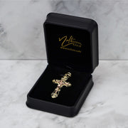 Two-tone gold crucifix pendant displayed inside an open black velvet jewelry box.